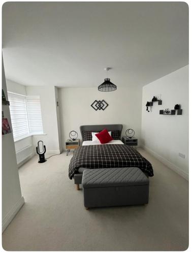 a bedroom with a bed with a red pillow on it at Bedroom in West Sussex with locks,Private Bathroom & Free Parking in Pulborough