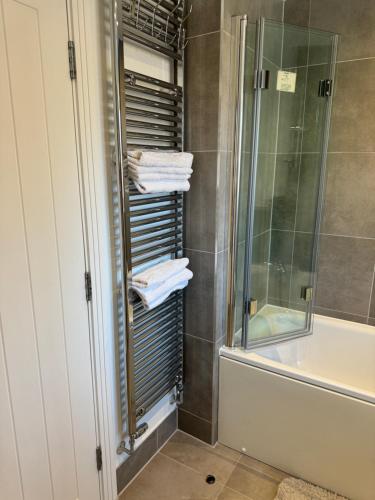 a bathroom with a shower and a towel rack at Bedroom in West Sussex with locks,Private Bathroom & Free Parking in Pulborough