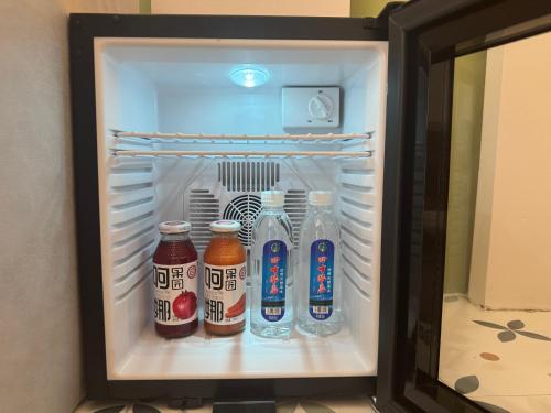 a refrigerator filled with bottles of soda at 红柳花雪山观景民宿 in Taxkorgan