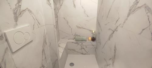 a white bathroom with marble walls and a toilet at PARIS AUTHENTIC HOUSE Métro 14 Station Hôpital Bicêtre, RER B Gentilly in Paris