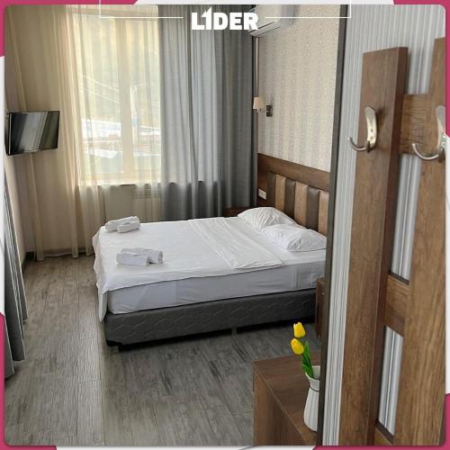 a hotel room with a bed with white sheets at Hotel Lider Complex in Vaykʼ