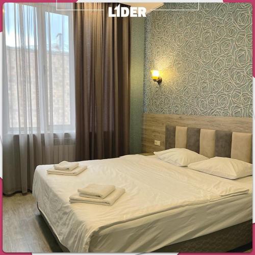 a bedroom with a large bed with towels on it at Hotel Lider Complex in Vaykʼ