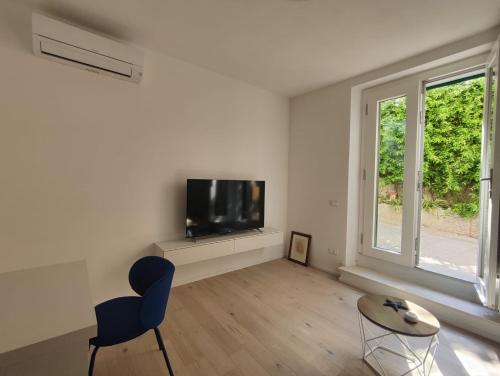 a living room with a tv and a blue chair at Casa Cotone 9 in Marciana Marina
