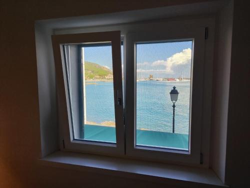 - une fenêtre avec vue sur une étendue d'eau dans l'établissement Casa Cotone 9, à Marciana Marina