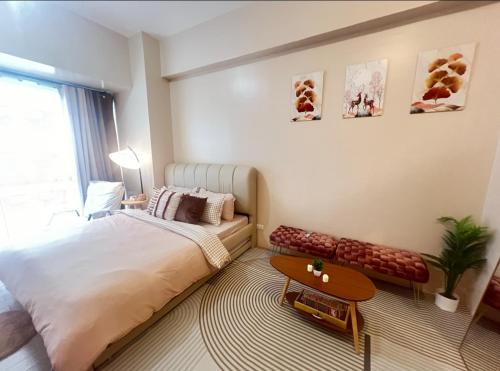 a bedroom with a large bed and a table at Cozy Condo at Eighty One Newport Blvd across NAIA Terminal 3 in Manila