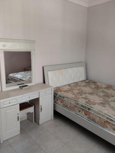 a bedroom with two beds and a desk and a mirror at شقة رائعة قريبة للبحر in Larache