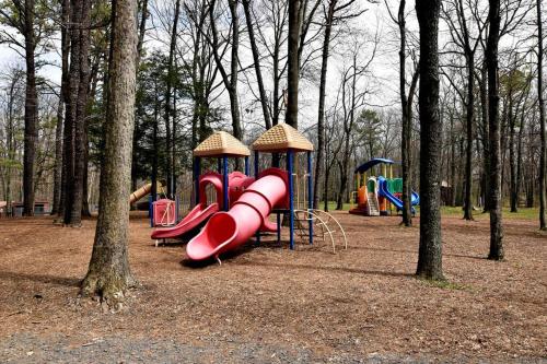 a playground with a red slide in a park at Ski-In Ski-Out Camelback Village Townhouse - 100 YDS From The Mountain in Crescent Lake