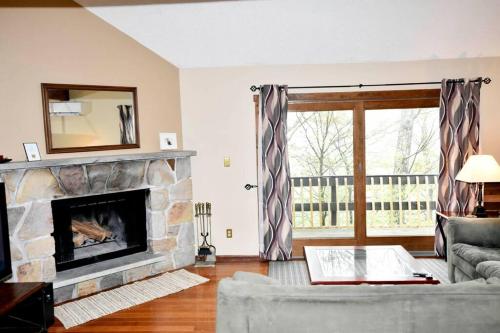 a living room with a fireplace and a couch at Ski-In Ski-Out Camelback Village Townhouse - 100 YDS From The Mountain in Crescent Lake