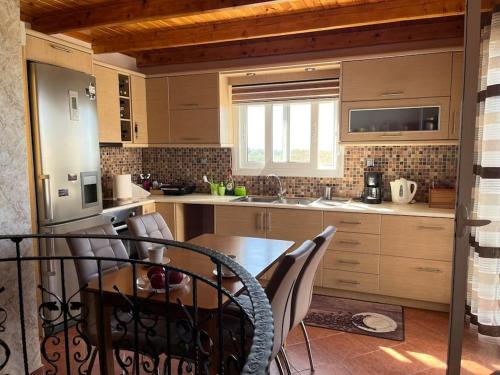 una cucina con un tavolo e sedie in una stanza di Oasis Escape Villa Loutraki a Loutraki