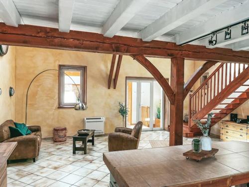 a living room with a staircase and a living room with chairs at Villa de Charme en Haute-Savoie in Clarafond