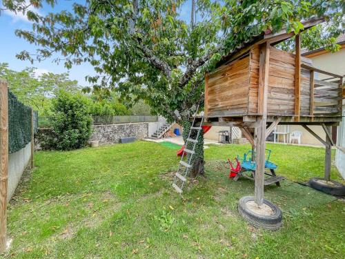 a tree house with a ladder in a yard at Villa de Charme en Haute-Savoie in Clarafond