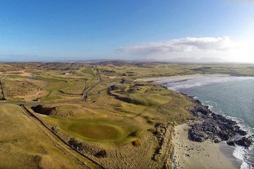an aerial view of a golf course next to the ocean at Pier view house in Ballyconneely