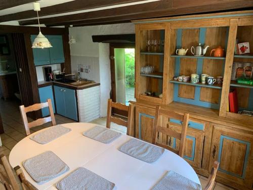 - une cuisine avec une table blanche dans une pièce dans l'établissement Gîte Au bout des Mynes avec vue panoramique, à Le Thillot
