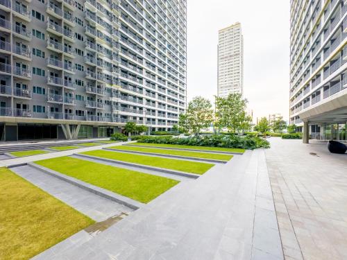 a courtyard in a building with grass and tall buildings at GemstoneBR in SMDC Fame Residences in Manila