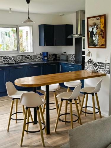 une cuisine avec une table et des chaises en bois dans l'établissement Maison Emeraude à Gan 64290, à Gan