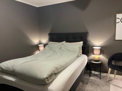 a bedroom with a large white bed with two lamps at Rom til leie i Tromsø - nært alt - flott standard in Tromsø