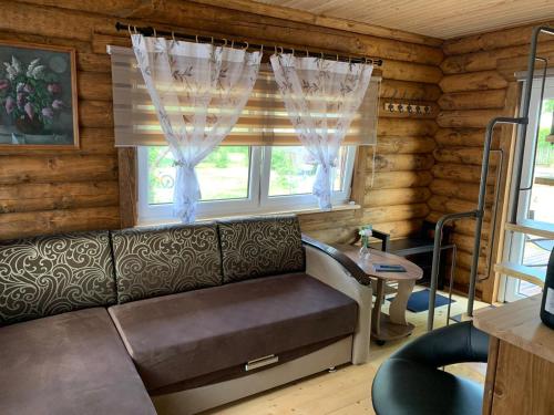 a living room with a couch and a window at Mājīga guļbūve pie jūras! in Bigauņciems