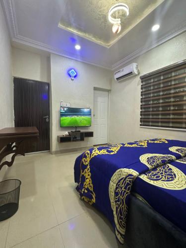 a bedroom with a bed and a flat screen tv at Lesley and Lindsey luxurious short let in Gwarinpa