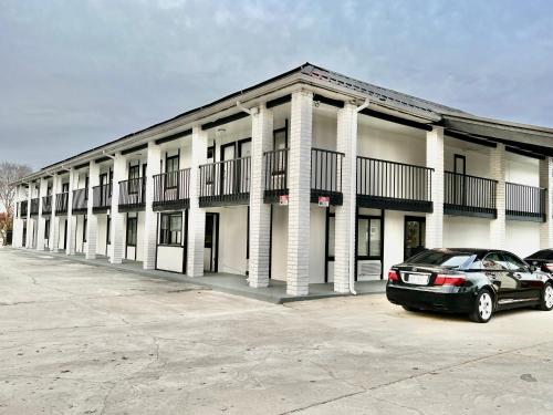 a building with a car parked in front of it at ECONOMY INN AND SUITES in Tulsa