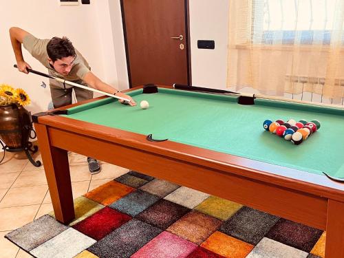 a man playing pool with a cue on a pool table at VILLA PATTY ASSISI con SPA in Assisi