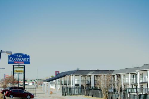 a building with a sign in front of it at ECONOMY INN AND SUITES in Tulsa