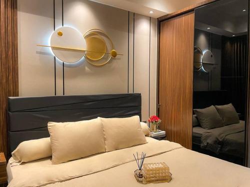 ein Schlafzimmer mit einem großen Bett und einem Spiegel in der Unterkunft Luxurious La Luna at Gold Coast Sea View in Jakarta
