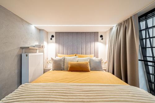 a bedroom with a large bed with yellow sheets at BalticSky Loft Premium, Apartament K o ł o b r z e g in Kołobrzeg