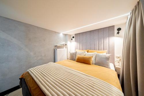 a bedroom with a large bed with yellow sheets at BalticSky Loft Premium, Apartament Kołobrzeg, Basen, Jacuzzi, Sauna in Kołobrzeg