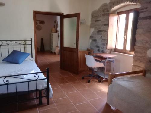 a bedroom with a bed and a desk and a window at Casa Pietro in Valledoria