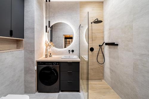 a bathroom with a washing machine and a mirror at BalticSky Loft Premium, Apartament Kołobrzeg, Basen, Jacuzzi, Sauna in Kołobrzeg