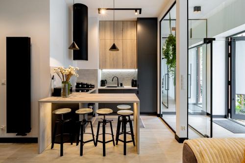 a kitchen with a island with bar stools at BalticSky Loft Premium, Apartament K o ł o b r z e g in Kołobrzeg