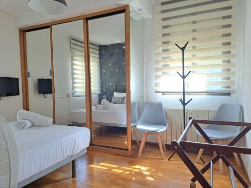 a bedroom with a mirror and a bed and a chair at Casa Ángel Ayuntamiento Centro in Logroño