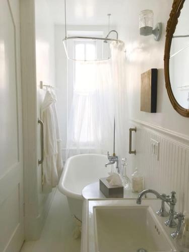 a white bathroom with a sink and a tub at Church Des Artistes in Kingston