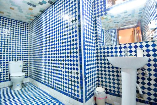 a blue and white bathroom with a toilet and a sink at Riad Dilar Fes & Spa in Fès