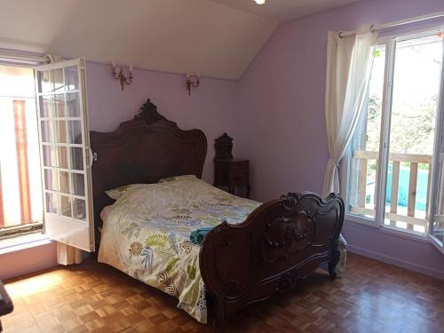 a bedroom with a bed in a room with windows at La Maison d'Emma, 10 p, grand spa, 1 h15 de Paris in Venon