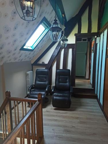 two chairs sitting in a room with a staircase at La Maison d'Emma, 10 p, grand spa, 1 h15 de Paris in Venon