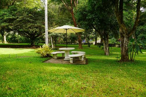 a picnic table and an umbrella in a park at Quinta Playa Blanca in Punta Leona