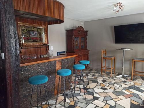 a bar with blue stools in a room at La Maison d'Emma, 10 p, grand spa, 1 h15 de Paris in Venon