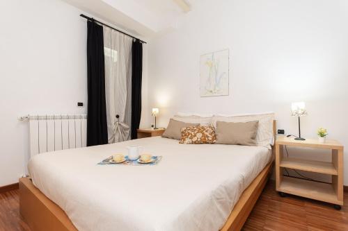 a bedroom with a bed with a tray of food on it at -2 Passi dal Mare- Centro Storico in Varazze