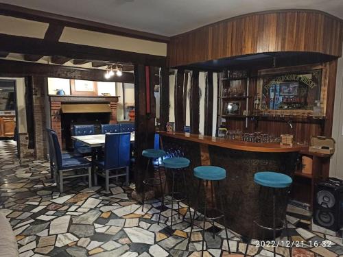 a bar with blue stools in a room at La Maison d'Emma, 10 p, grand spa, 1 h15 de Paris in Venon