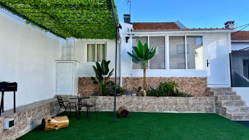 a house with a patio with green grass at J Home in Lisbon