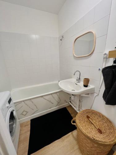 a bathroom with a sink and a washing machine at Appart équipé en plein cœur de Lisle Adam in LʼIsle-Adam