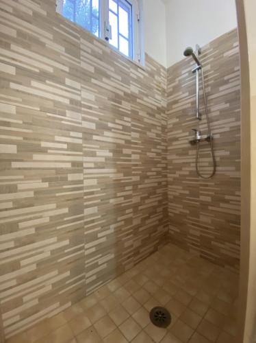 a bathroom with a shower with a stone wall at Camping Villaggio Pineta Al Mare in Specchiolla 