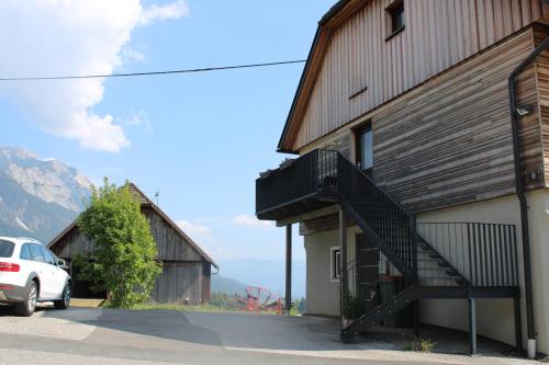 a white car parked next to a building with a staircase at Appartment Herzblick in Sankt Georgen im Gailtal