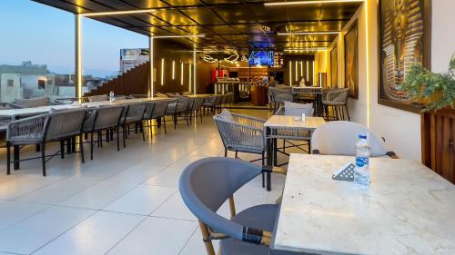 a restaurant with tables and chairs on a balcony at Giza Pyramids View Inn in Cairo