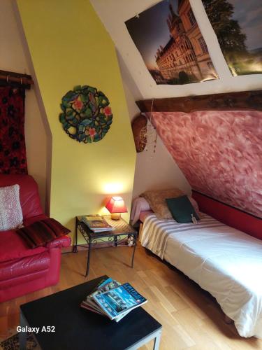 a room with a bed and a couch and a table at Chambres dans longère particulière in Dierre