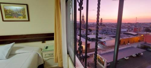 a room with a bed and a view of a city at Hotel San Francisco INN in Arequipa