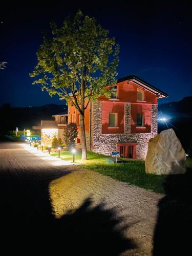 a building with a tree in front of it at night at Agriturismo Monte di Bebbio in Bebbio
