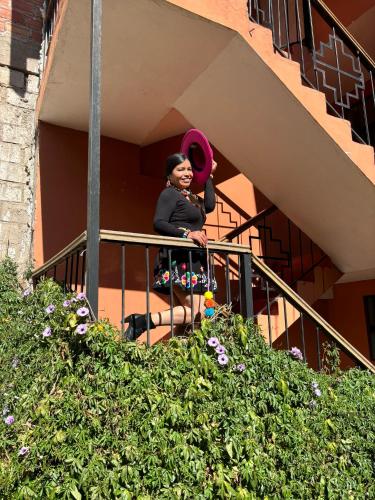 a woman sitting on a balcony holding a frisbee at Tambo Real Valle Sagrado in Yucay