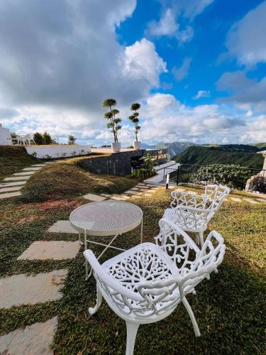 two white chairs and a table and a table at TRIP MOUNT in Vagamon